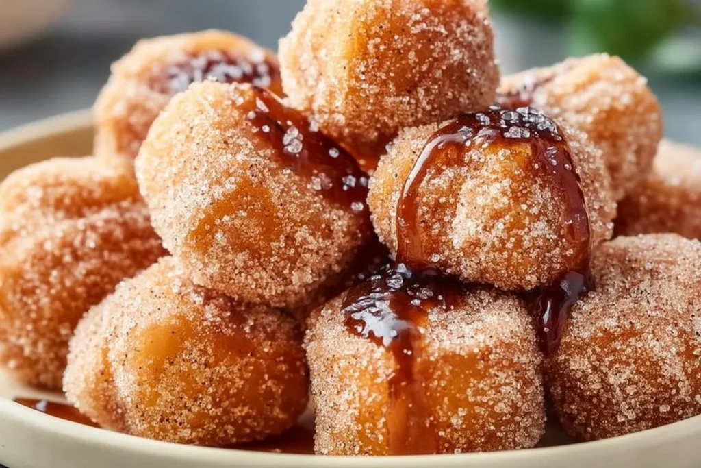Leckere Churro Bites mit Zimt-Zucker bestreut auf einem Teller.